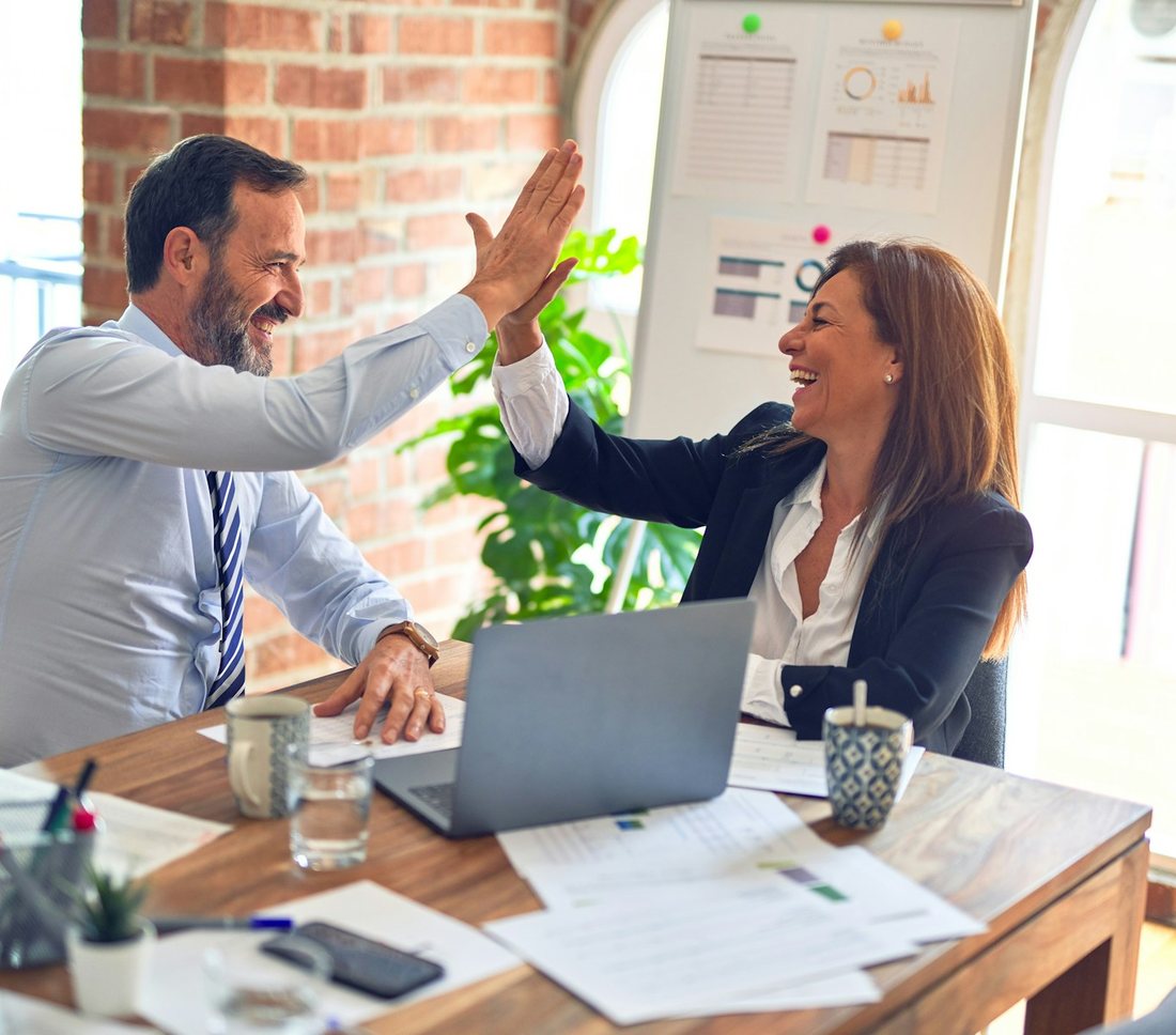 An accountant and a client celebrating good results at a desk